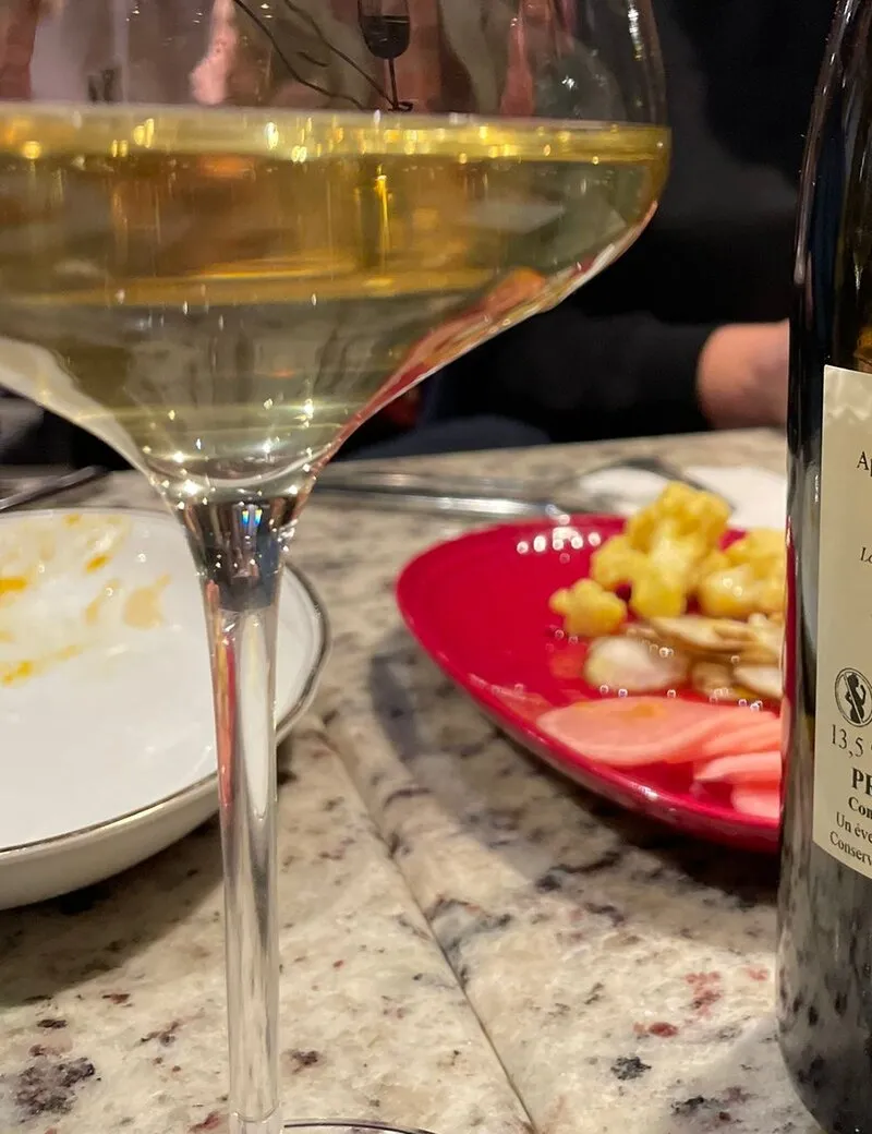 Natural wine glass with small plates at a Wroclaw wine bar